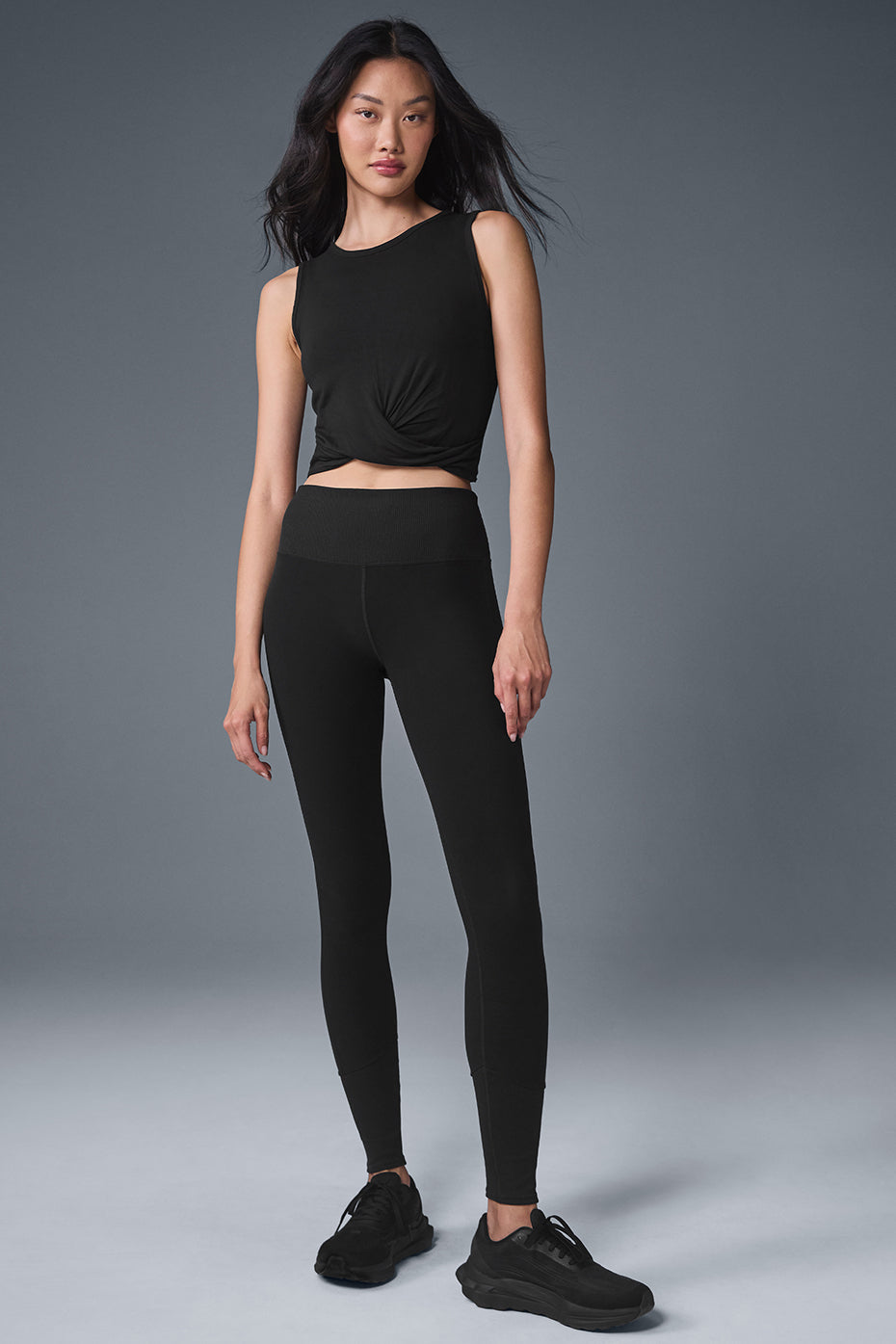 Front view of the black tank top with raw edge hem and wrap detail, perfect for activewear or casual outfits