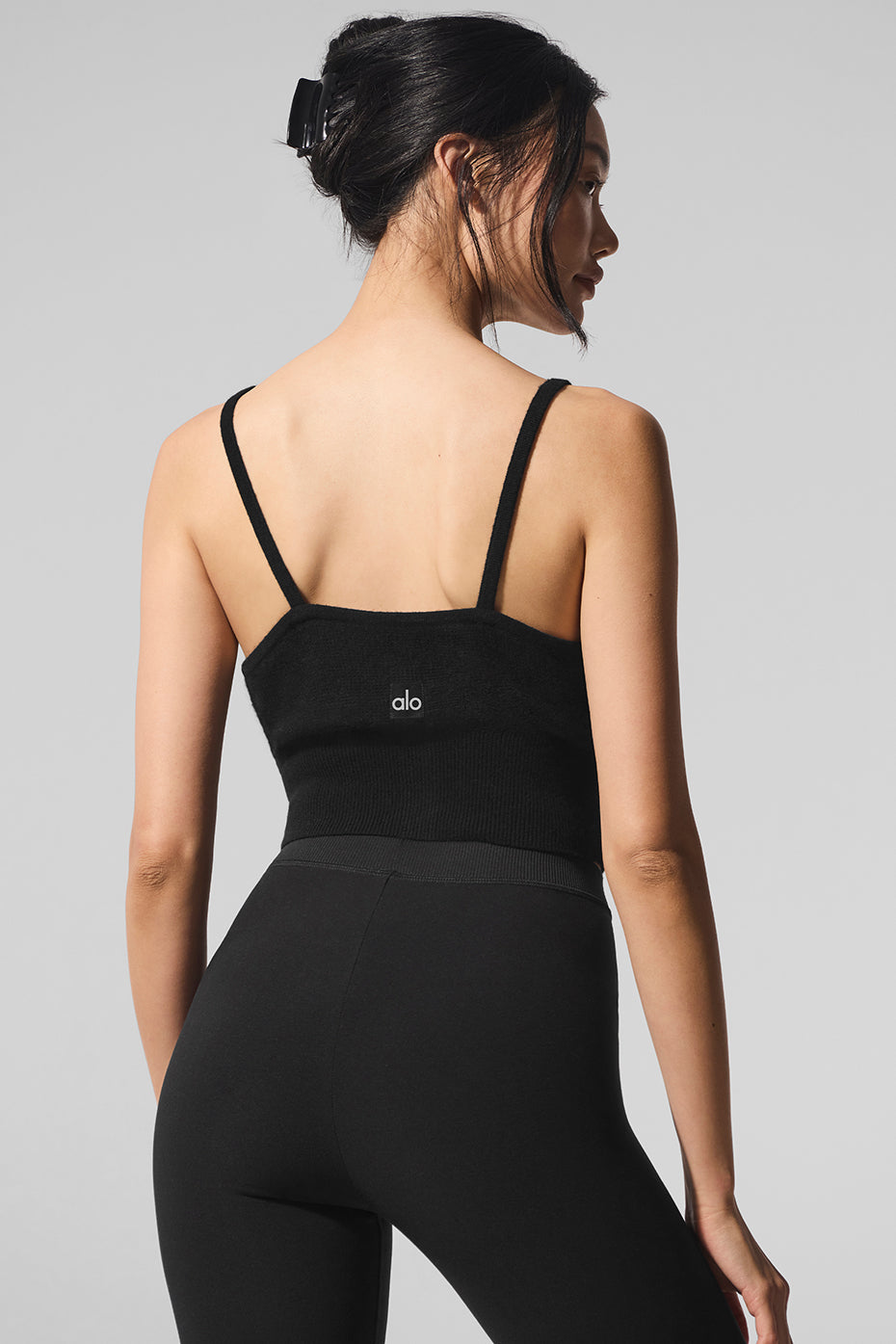 Front view of the sheer cashmere tank top in black, showcasing button details.