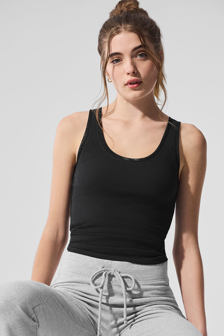 Model wearing the black mesh long sleeve top layered under a denim jacket