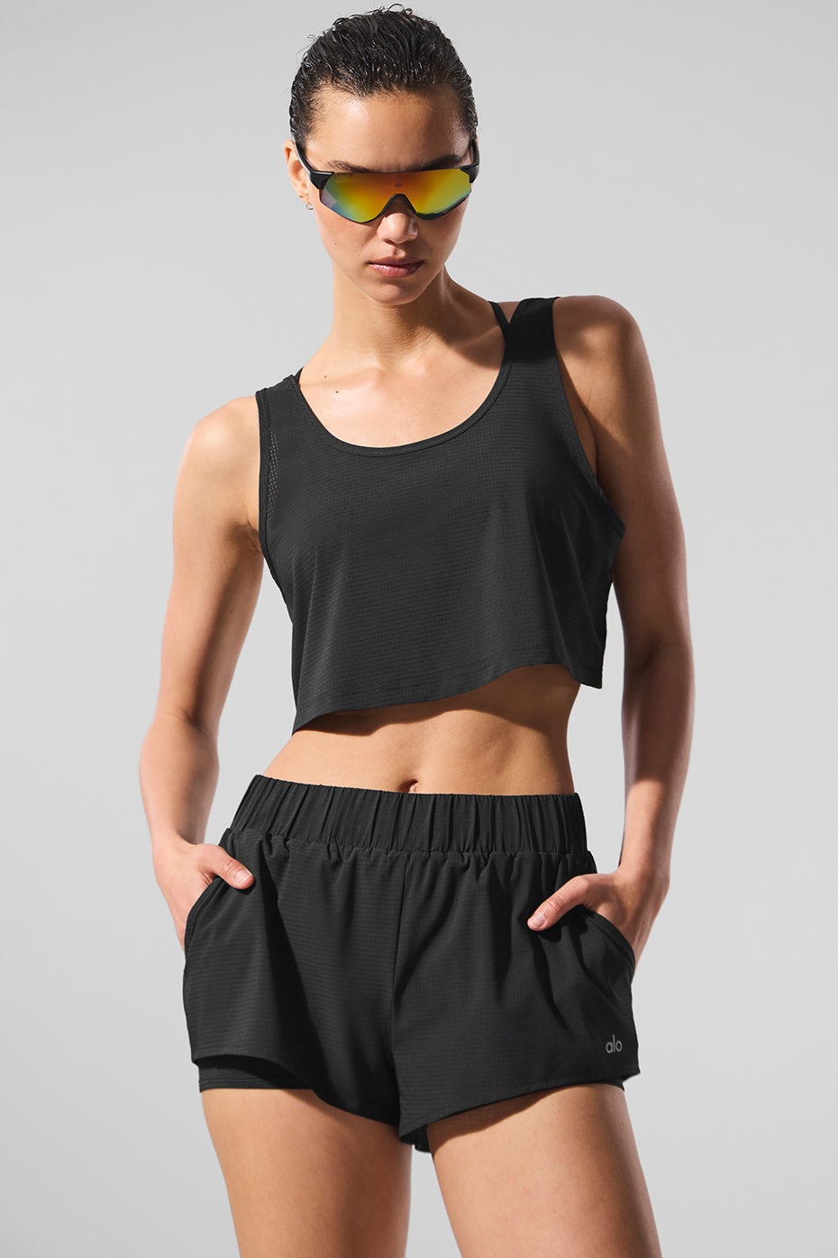 Front view of sporty chic cropped tank top for women during a beach run.