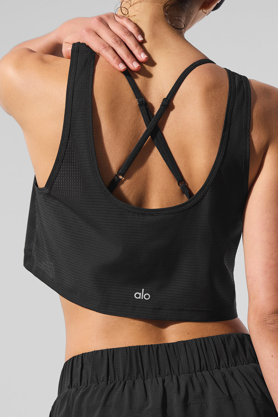Front view of sporty chic cropped tank top for women during a beach run.