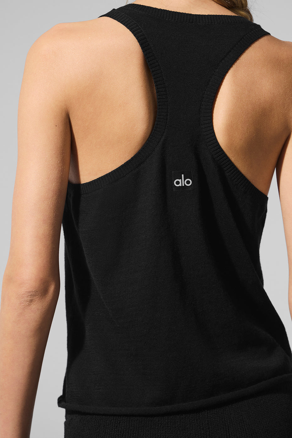 Front view of the black Henley tank sweater, showcasing its button details.