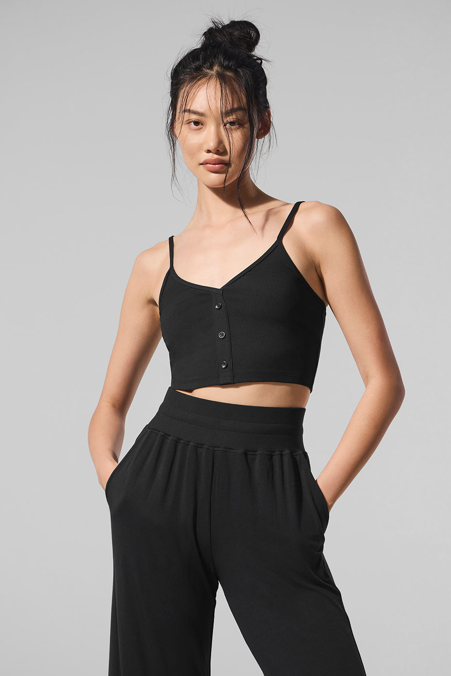 Front view of the black ribbed tank top showcasing its V-neckline and buttons.