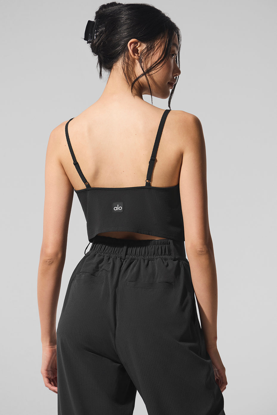 Front view of womens lightweight cotton tank top in black, styled with travel-friendly accessories