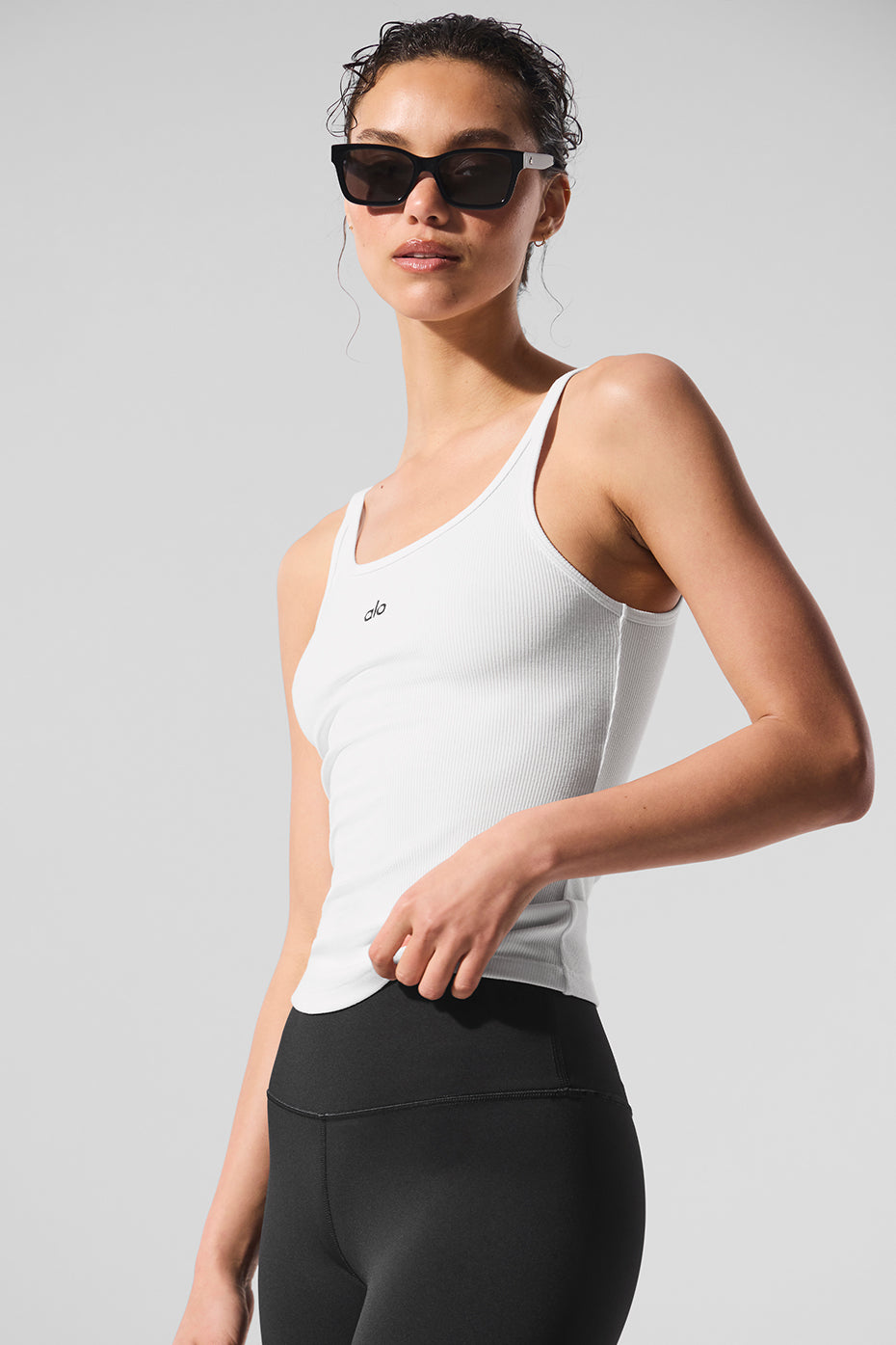 Front view of a white ribbed tank top styled with casual jeans