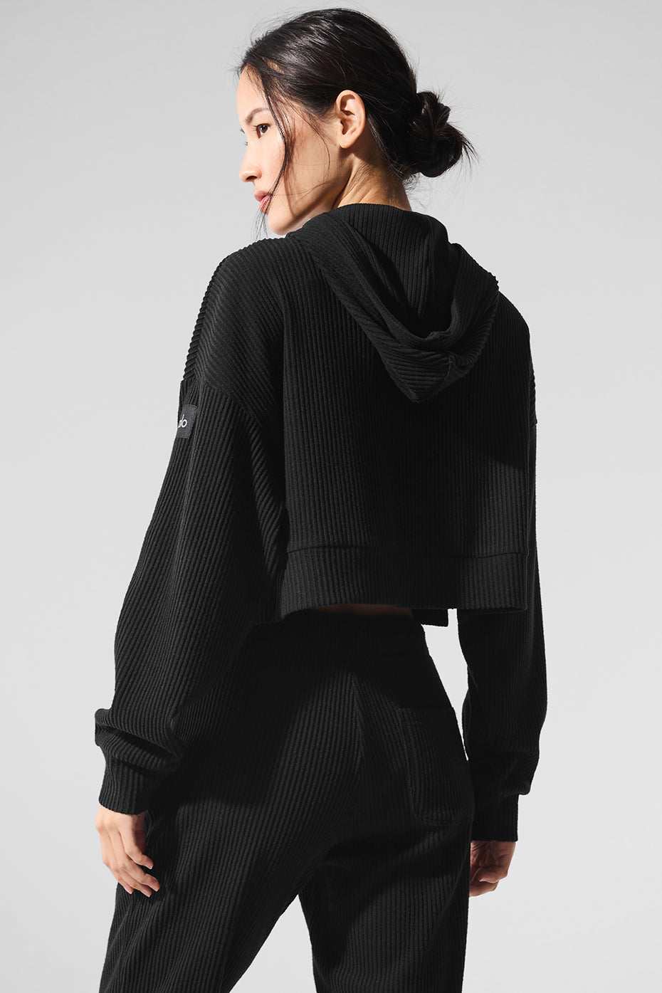 Side view of the black hoodie showing side slits and relaxed fit