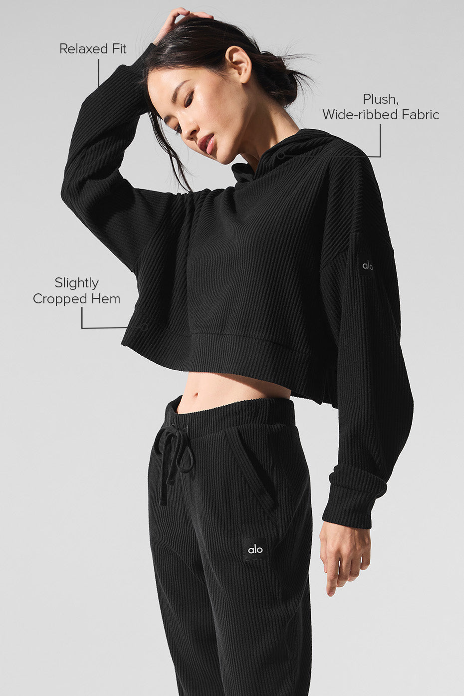 Model wearing the cropped silhouette Muse hoodie while relaxing outdoors