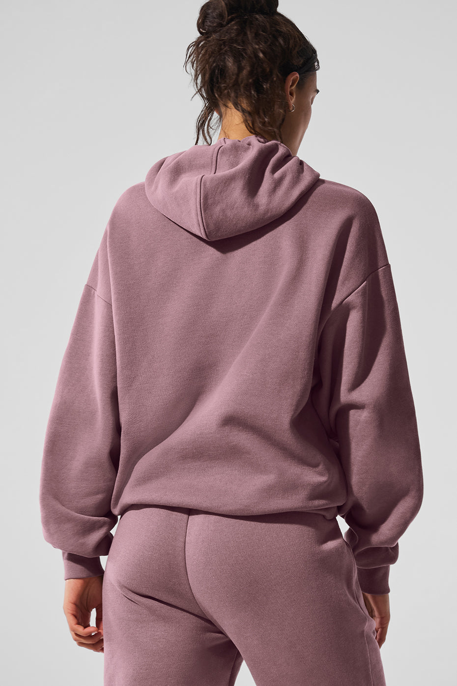 Side angle of womens camo hoodie styled with matching sweatpants for studio wear