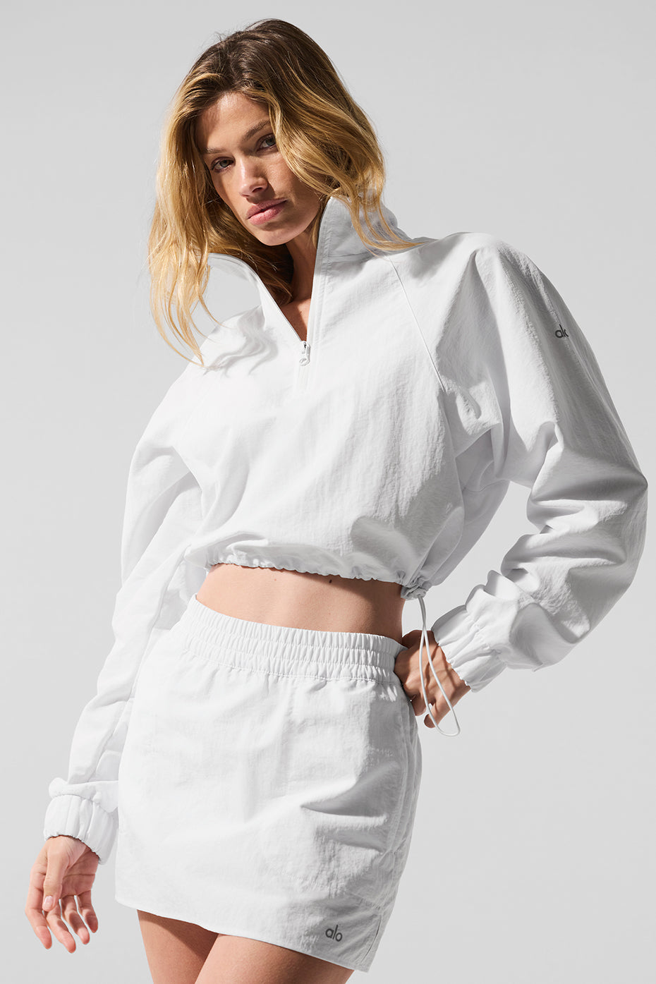 Front view of the white athletic pullover with quarter zip, styled for casual wear