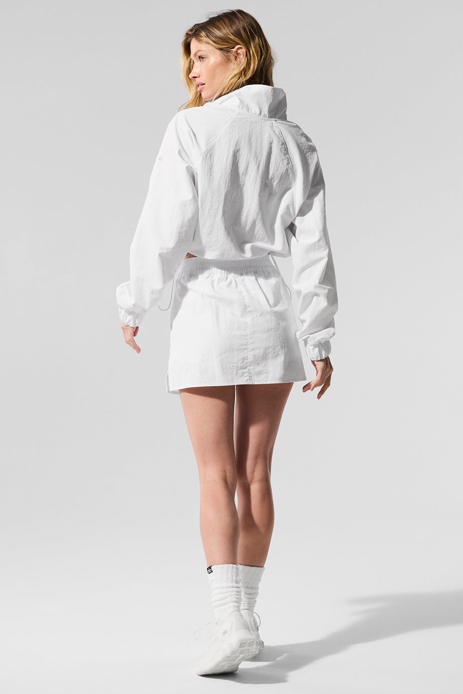 Close-up of the white cropped quarter zip pullover showing the crinkle woven fabric texture