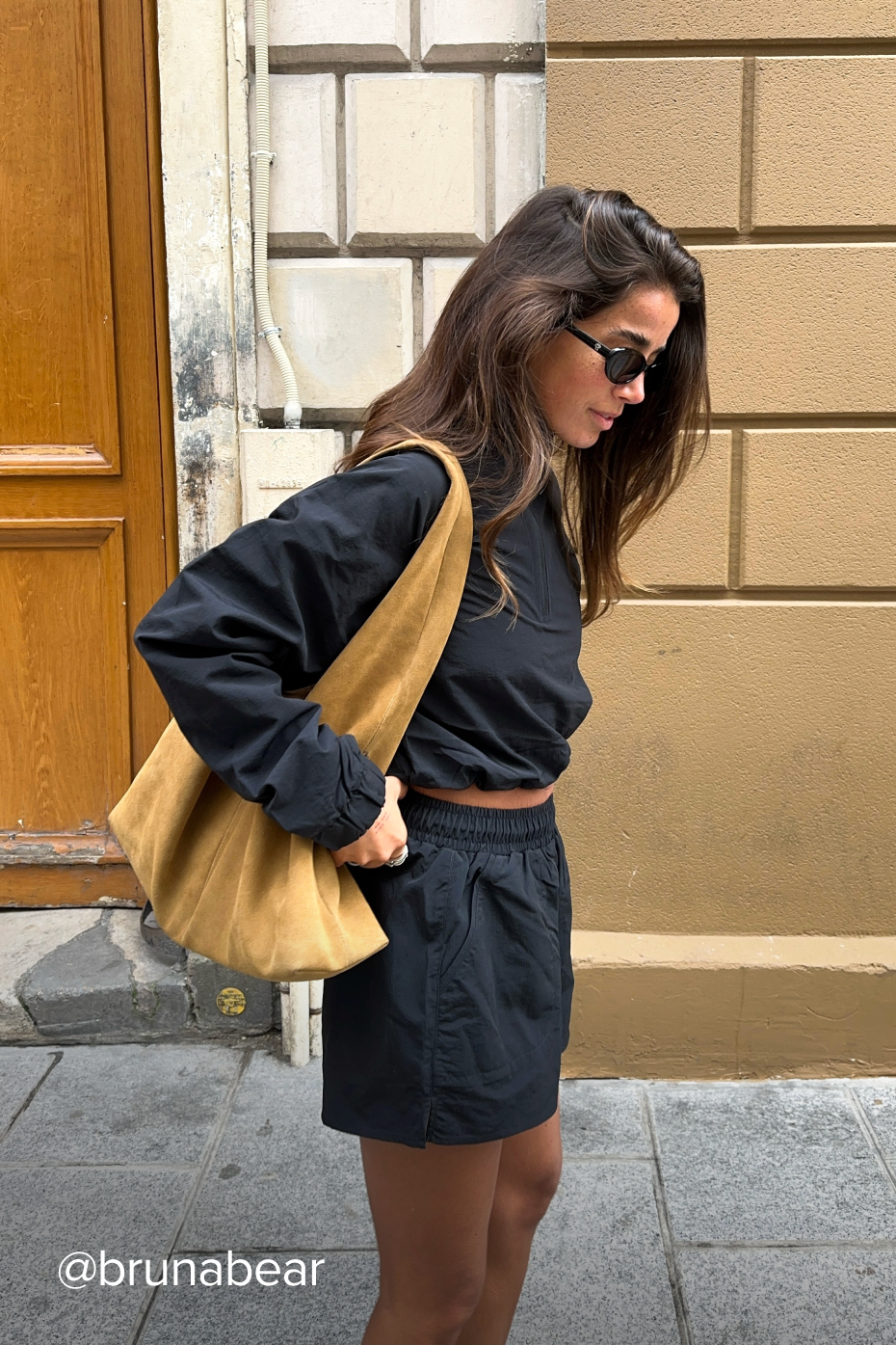 Back view of black cropped pullover with minimalist branding