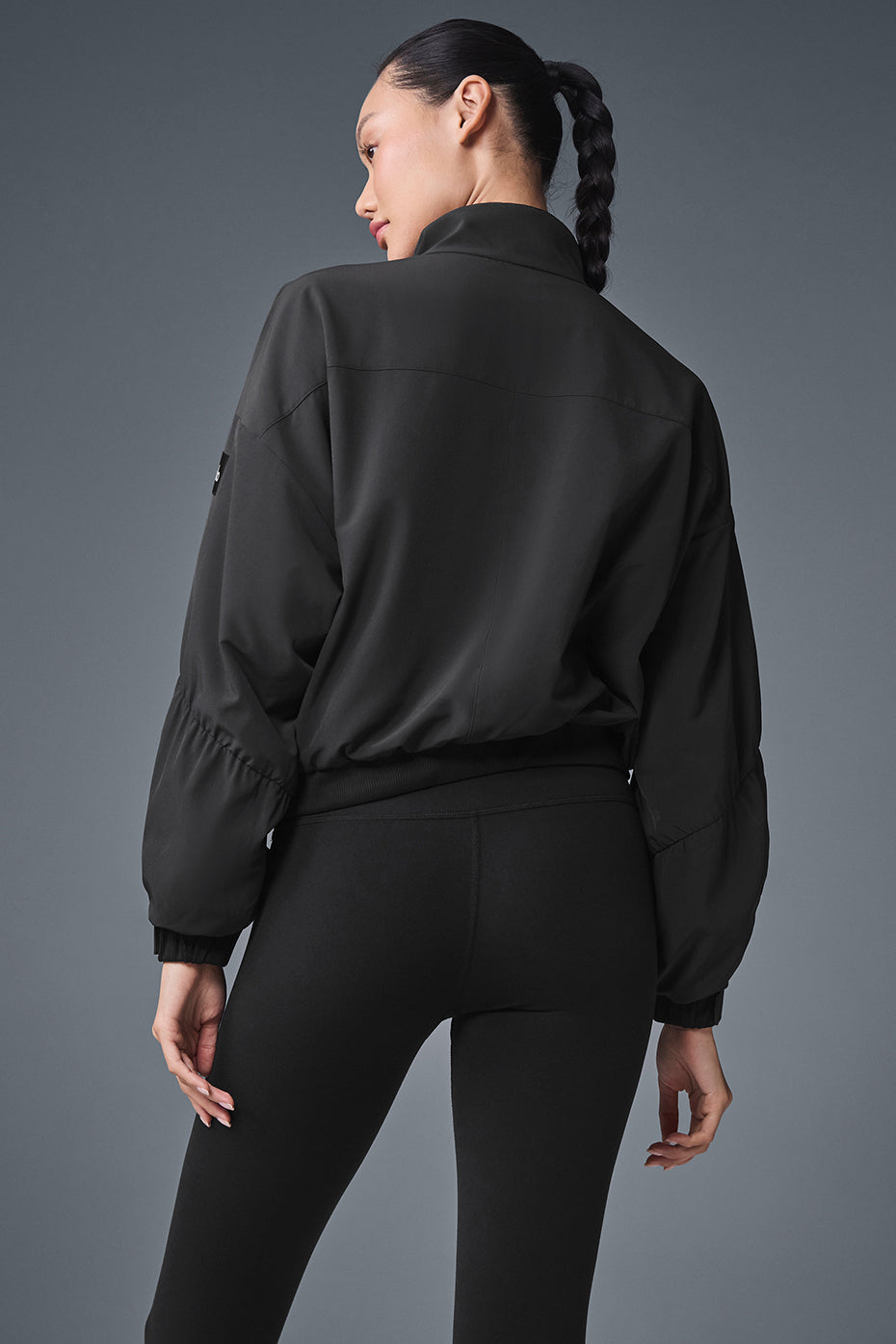 Model showcasing the cropped leather jacket with adjustable bungee detail.