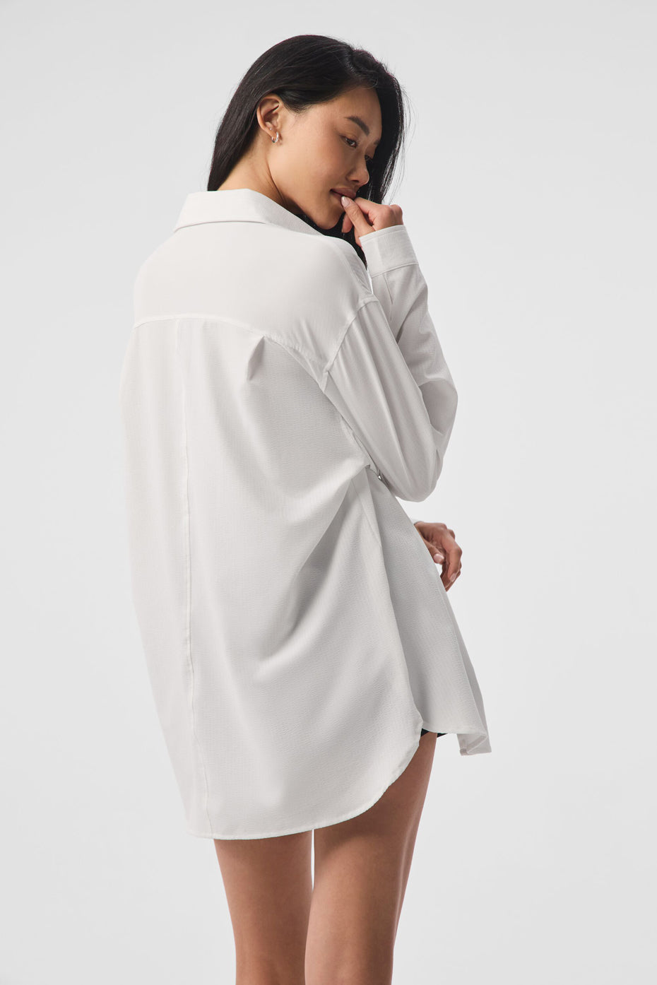 Back view of white button down shirt tucked into high-waisted trousers