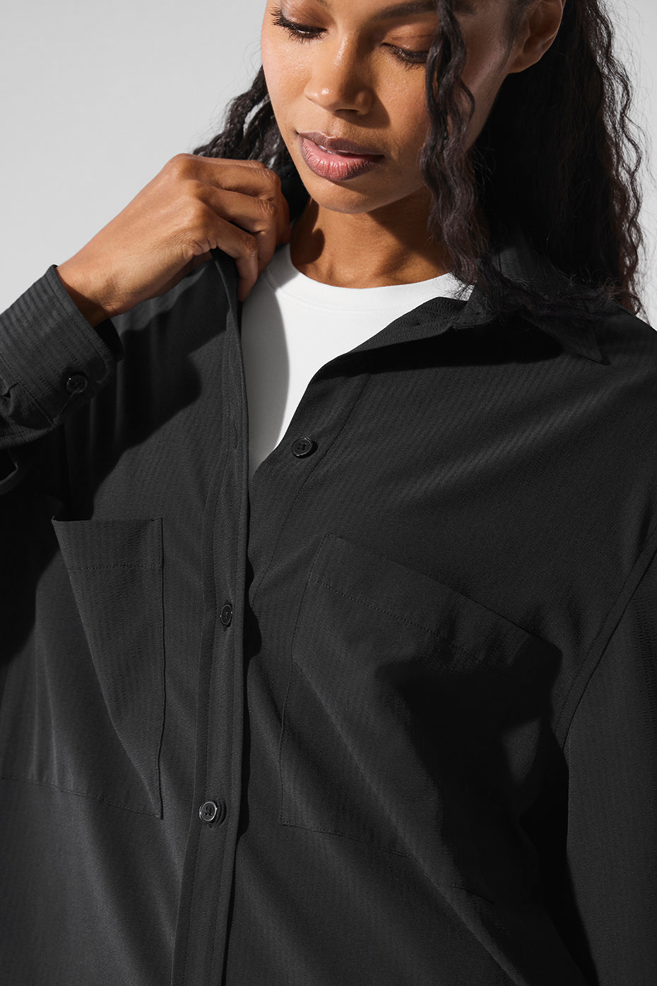 Model wearing the oversized long sleeve button down shirt with high-waisted trousers.