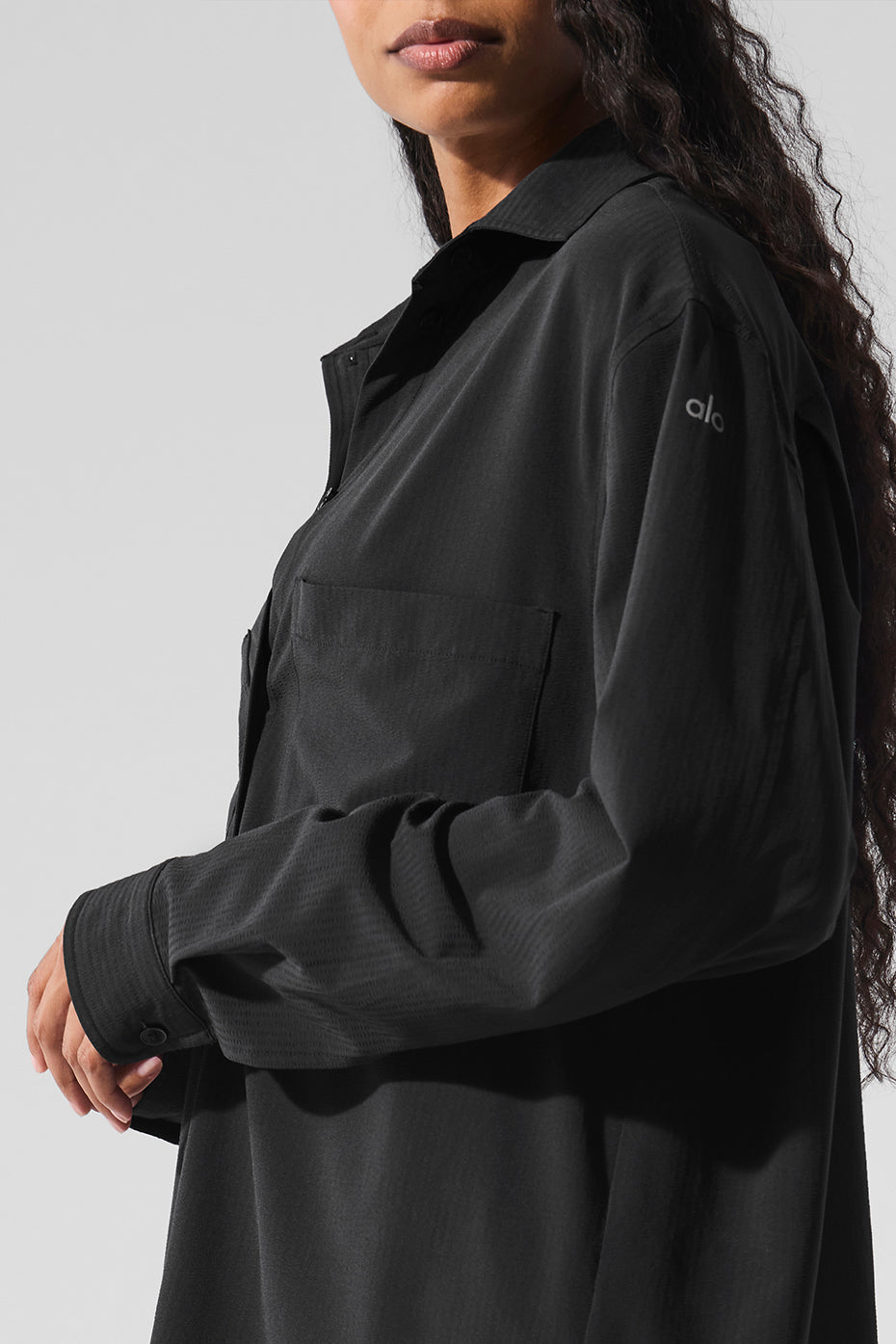 Model wearing the oversized long sleeve button down shirt with high-waisted trousers.