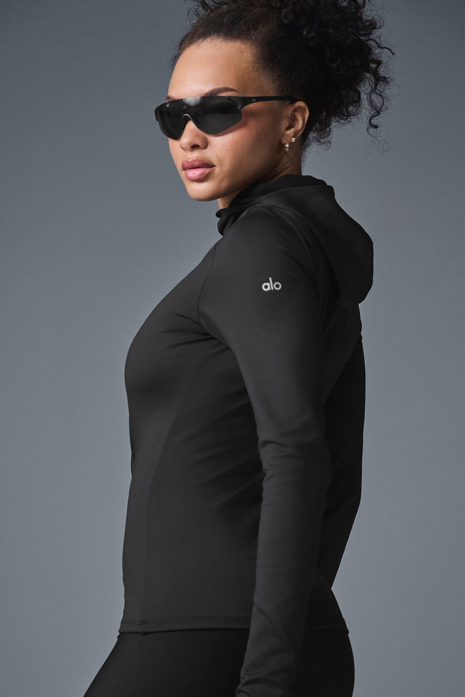 Woman jogging in rainy conditions wearing the black hooded running top