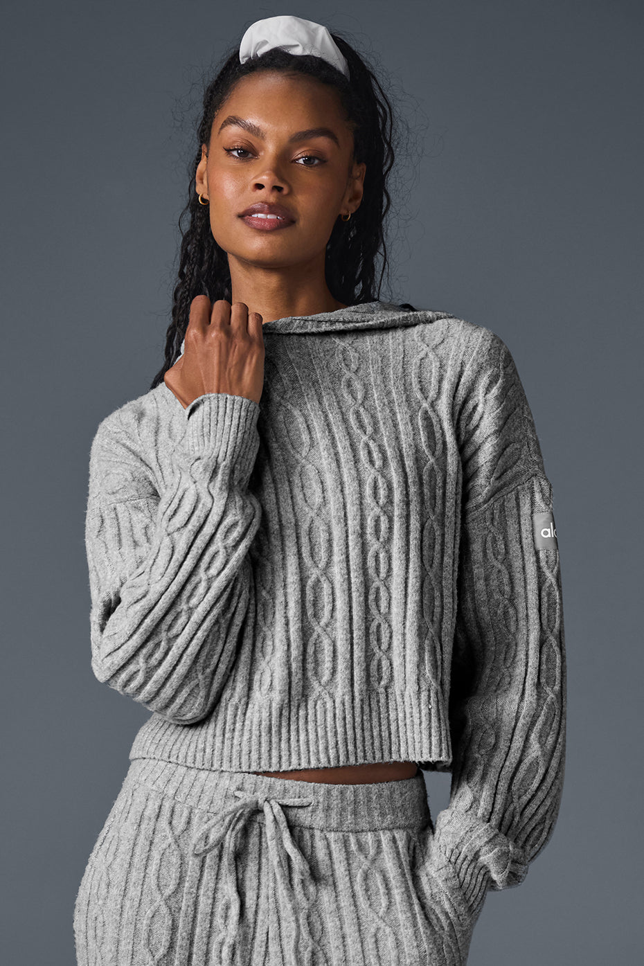 Close-up of cable knit hoodie texture, showing winter-ready fabric.