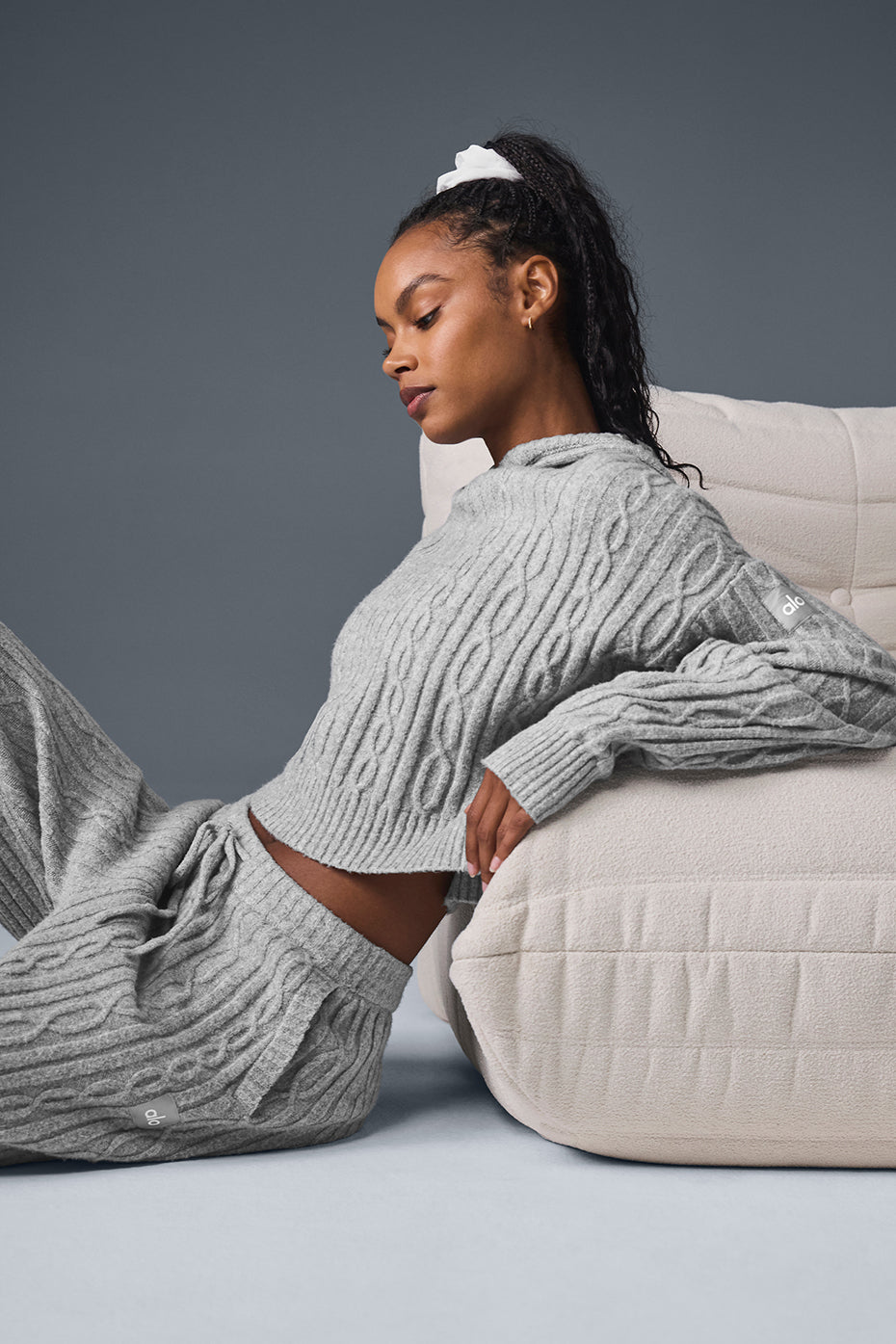 Close-up of cable knit hoodie texture, showing winter-ready fabric.