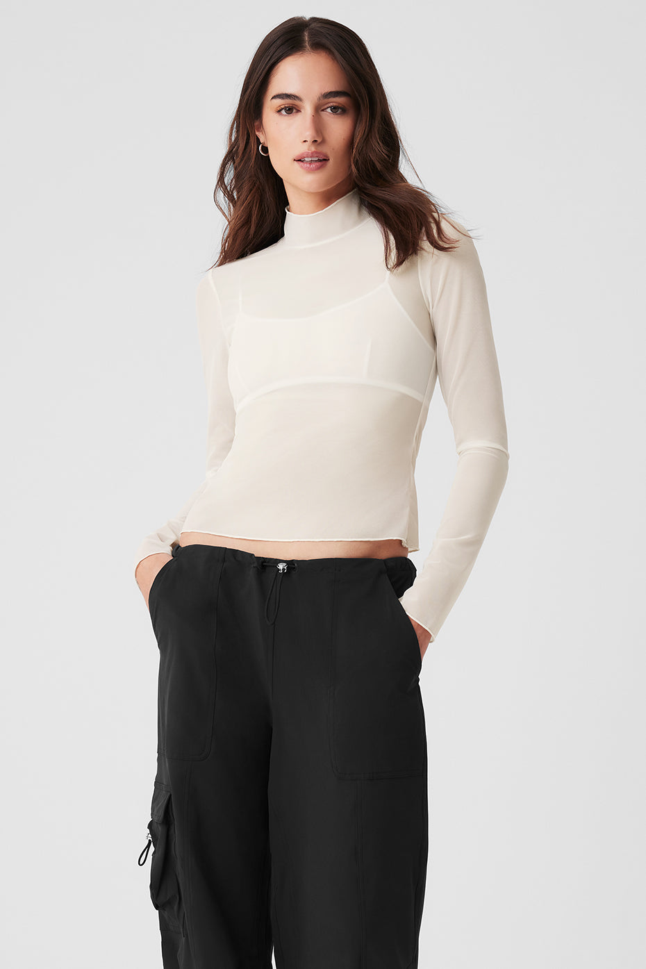 Front view of ivory sheer mock neck long sleeve top on a model.