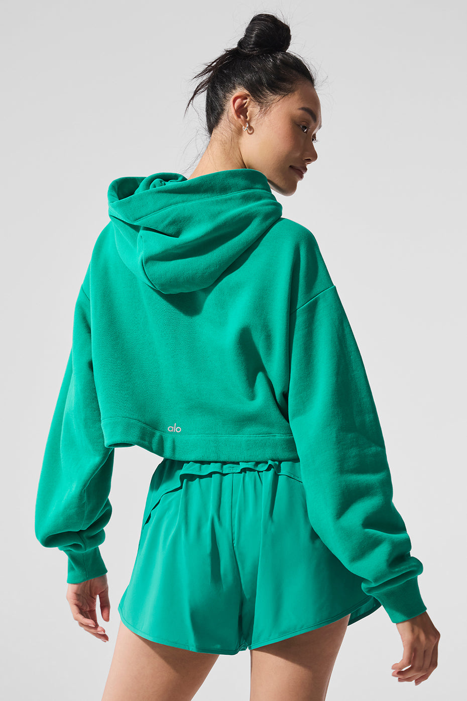 Model wearing the Spruce Green comfort hoodie with high-waisted jeans.