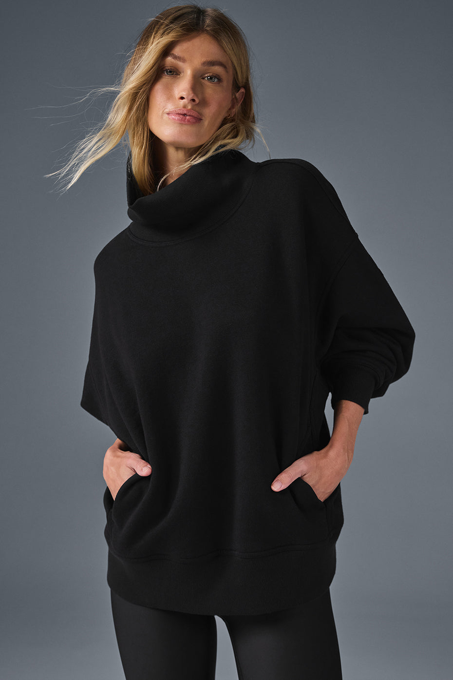 Front angle of black cozy sweater styled with joggers for everyday wear.