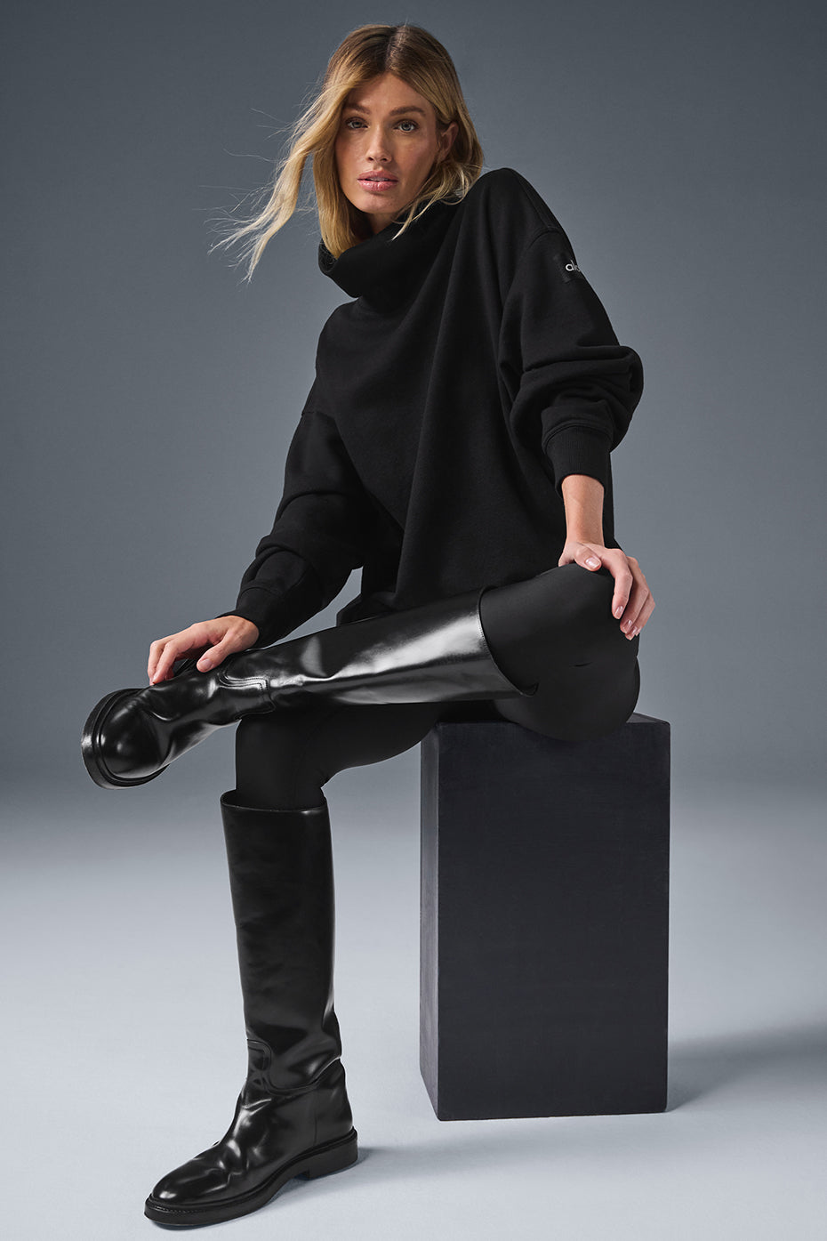 Front angle of black cozy sweater styled with joggers for everyday wear.