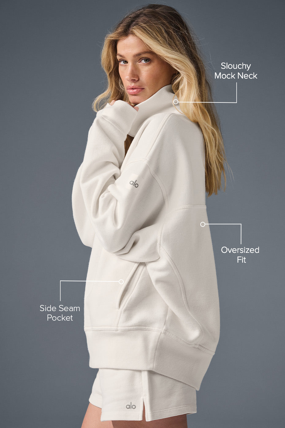 Detail shot of sweaters mock neck and ribbed hem, laid flat on wooden surface