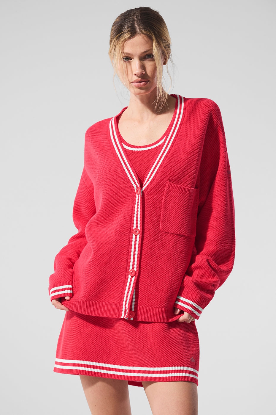 Model wearing the Tennis Club cardigan layered over a casual outfit.