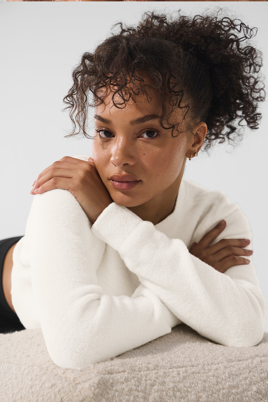 Model wearing ivory cropped cardigan styled with high-waisted jeans