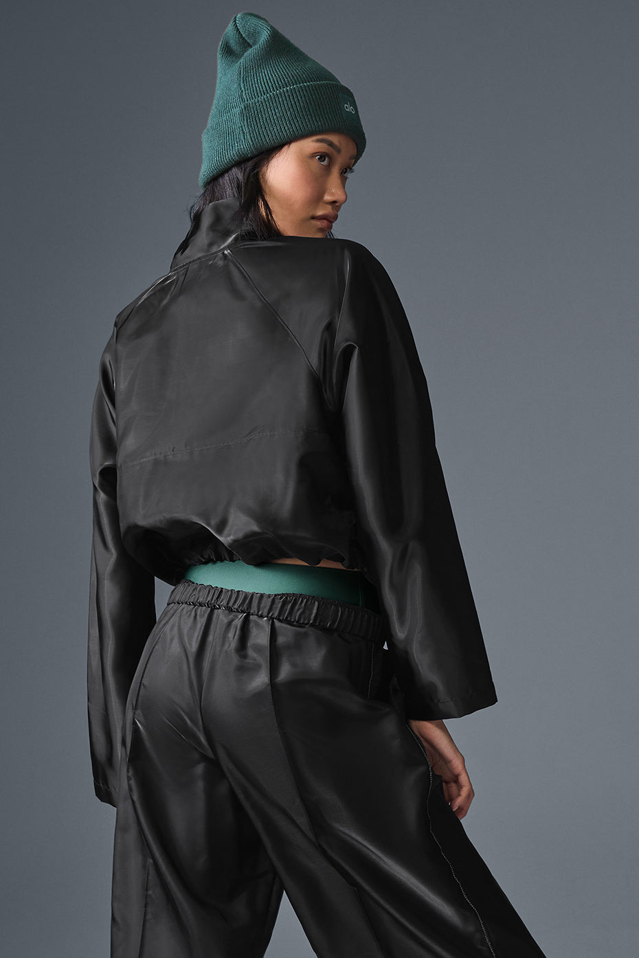 Pairing the chic pullover with wide leg track pants for a trendy outfit.