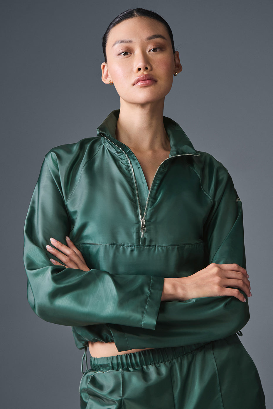 Model wearing the cropped pullover with matching track pants during outdoor workout