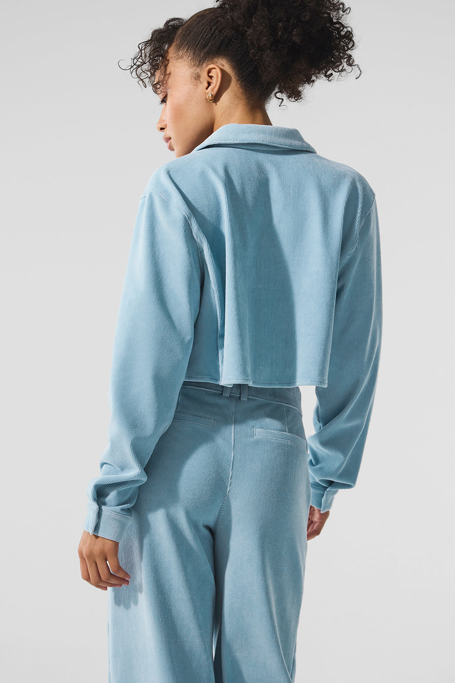 Mens cropped button down shirt styled with wide leg trousers for a chic look.
