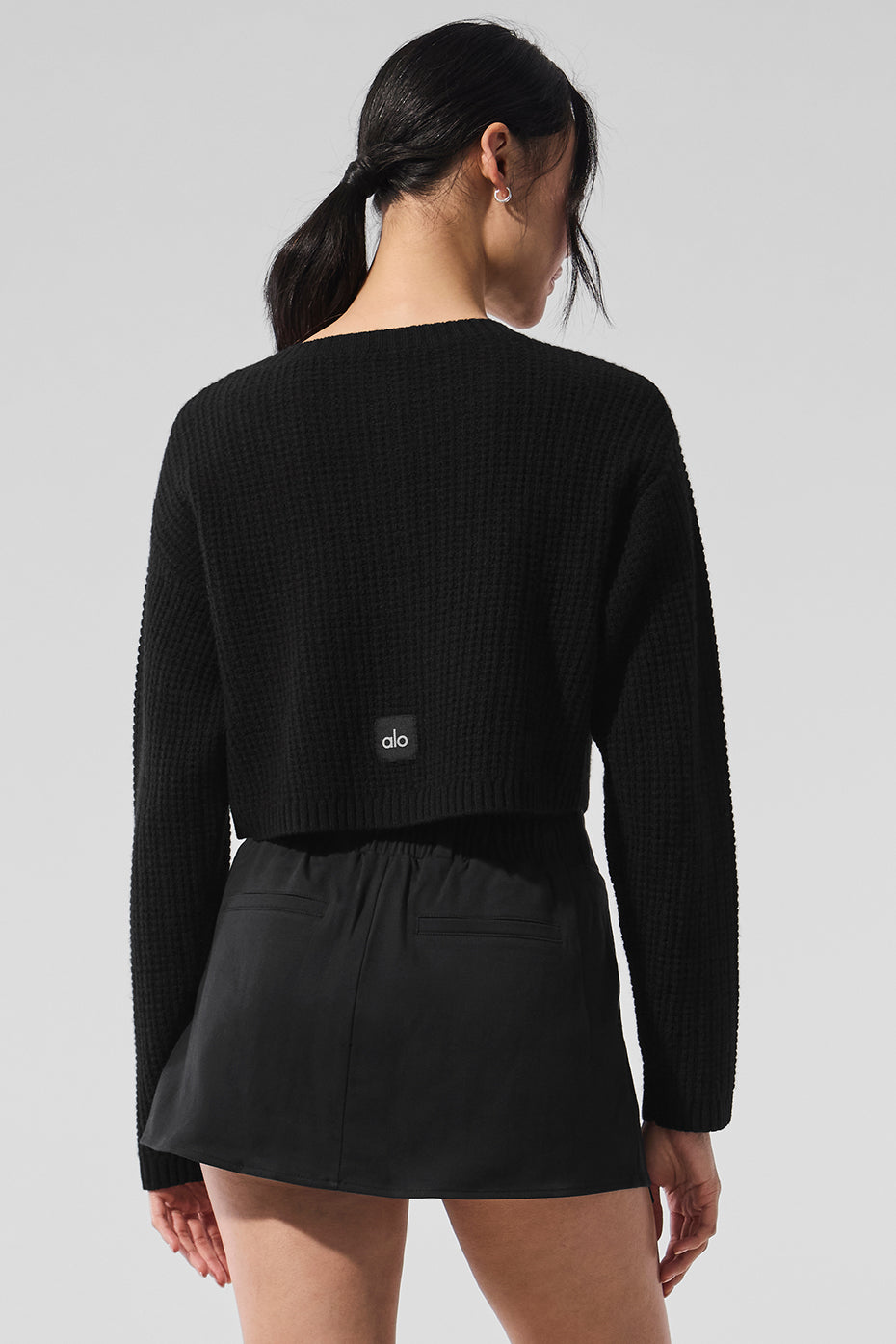 Woman styling long black cardigan with jeans