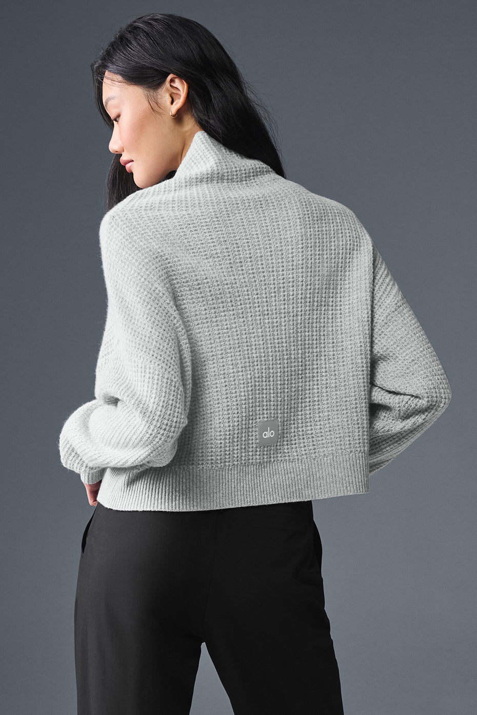 Oversize cashmere pullover worn with stylish trousers for a chic outfit.