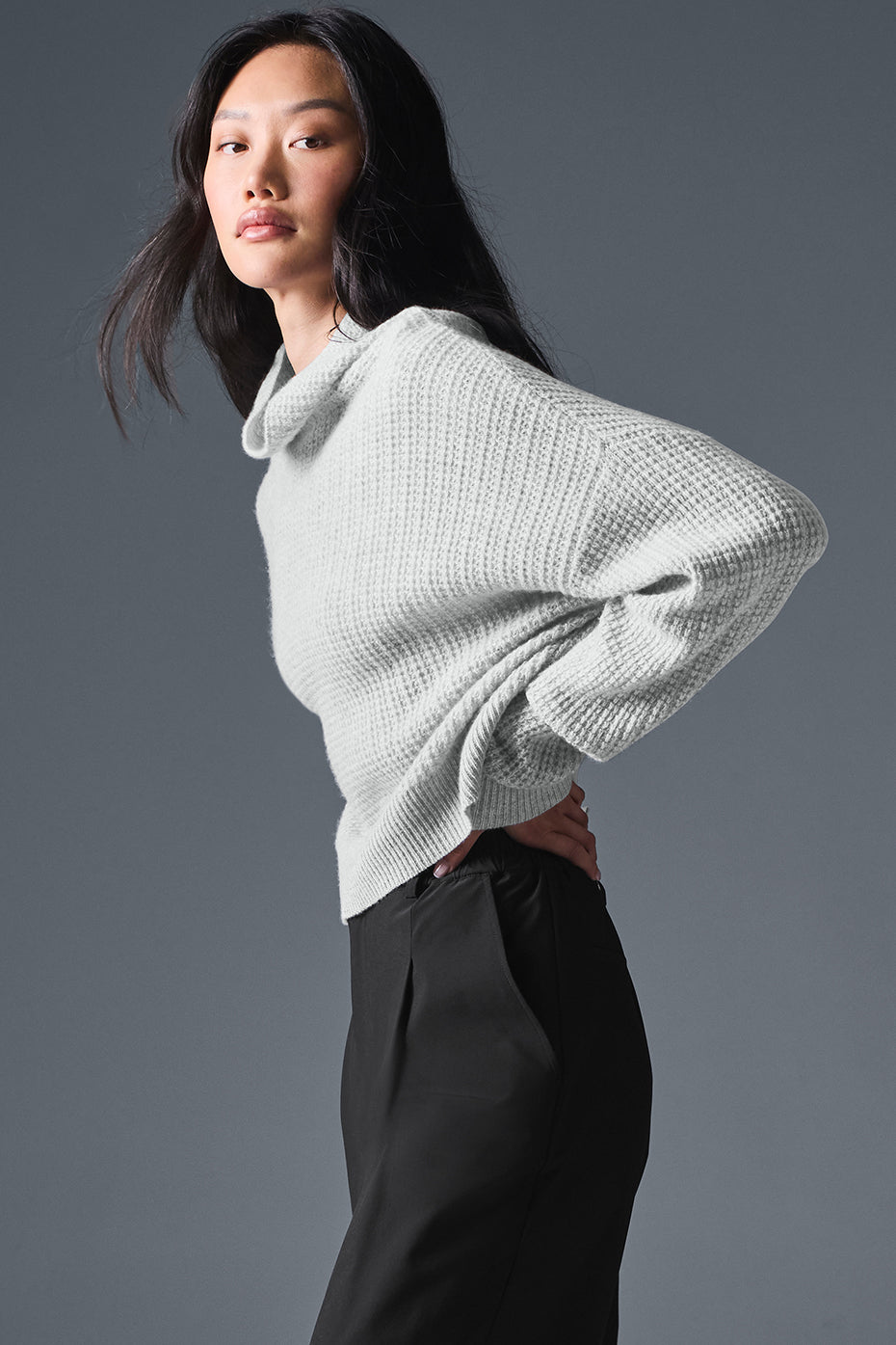 Mens cashmere pullover sweater displayed in a cozy living room setting.