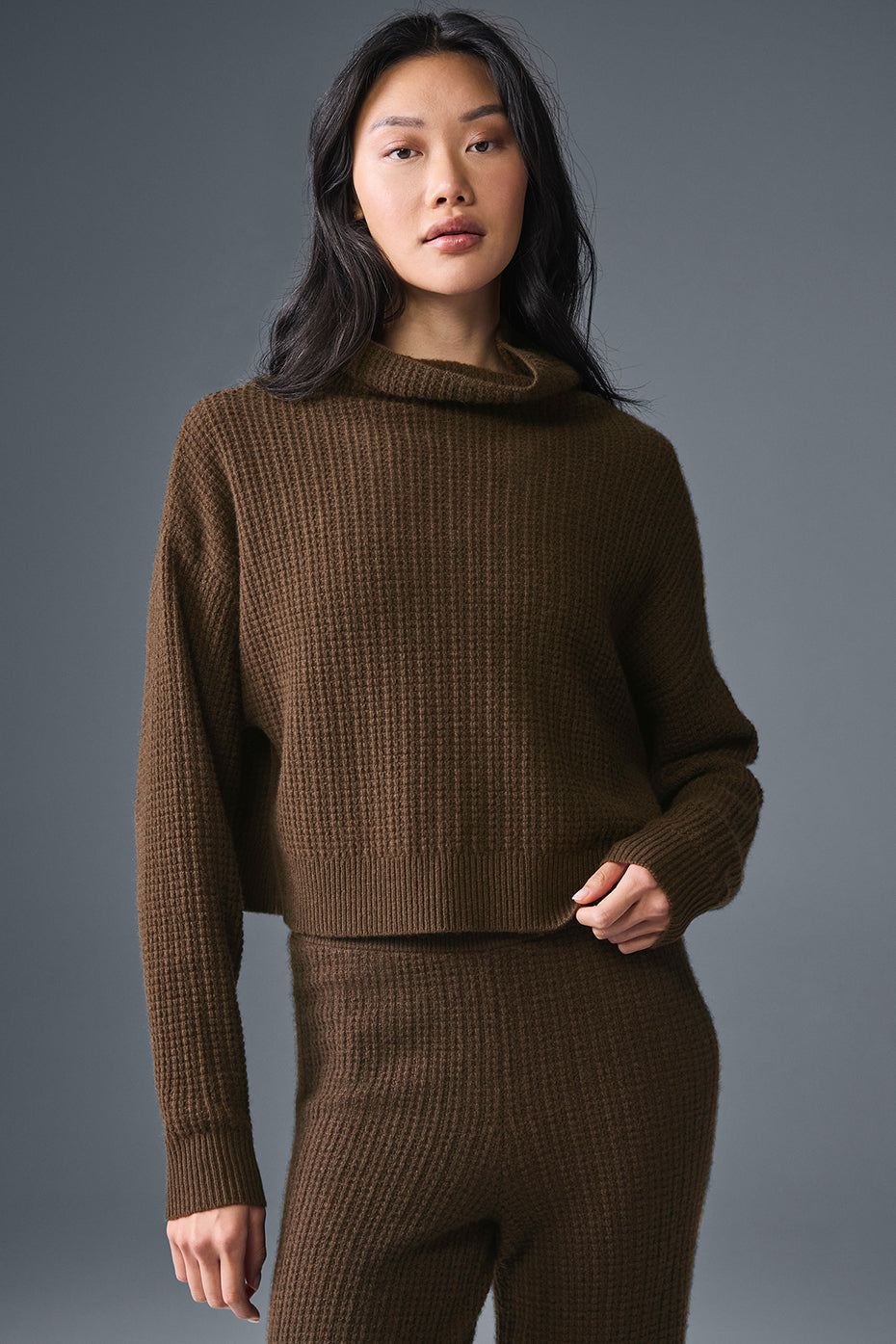 Side view of the espresso waffle turtleneck styled with dark trousers