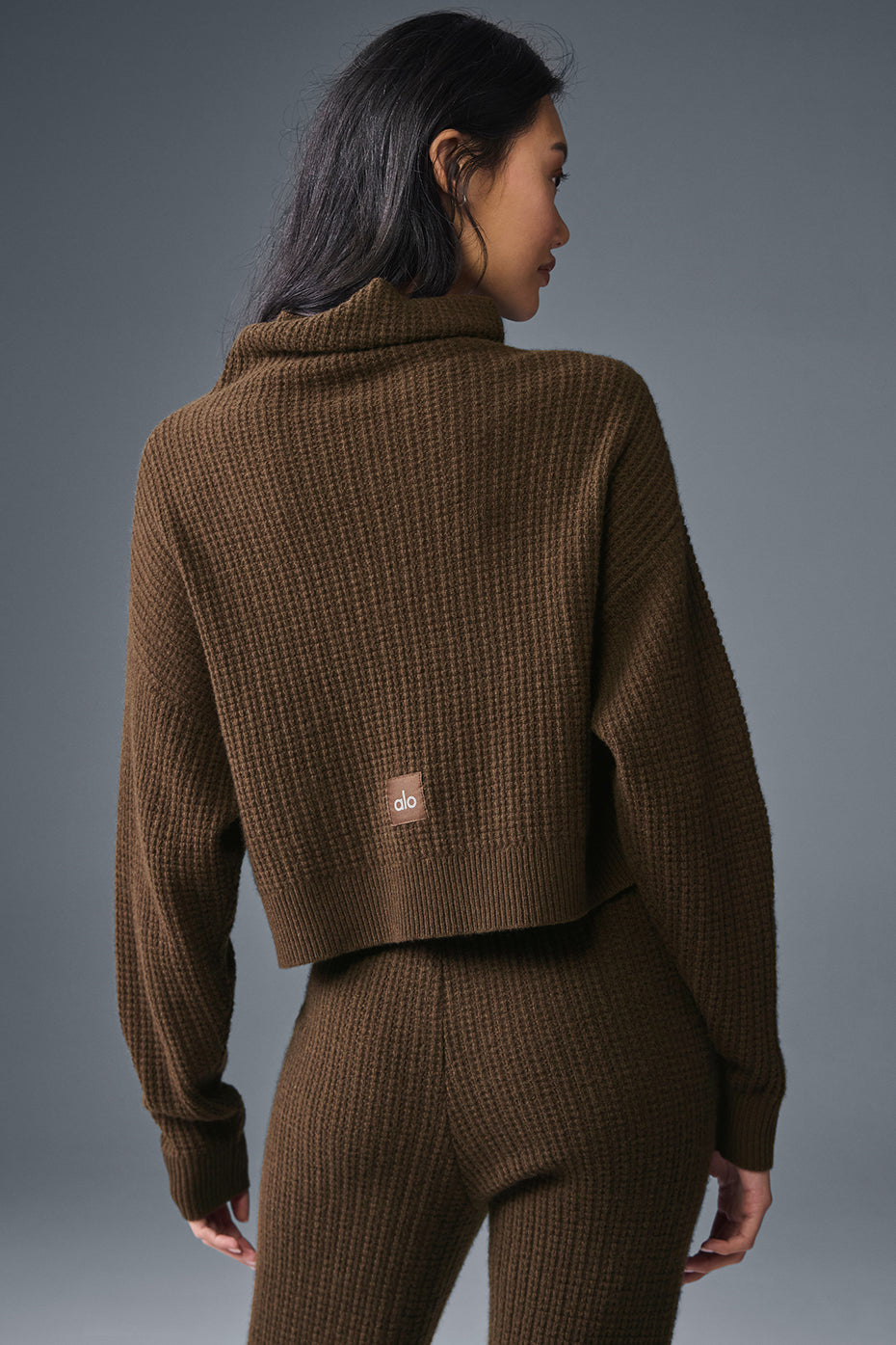 Side view of the espresso waffle turtleneck styled with dark trousers