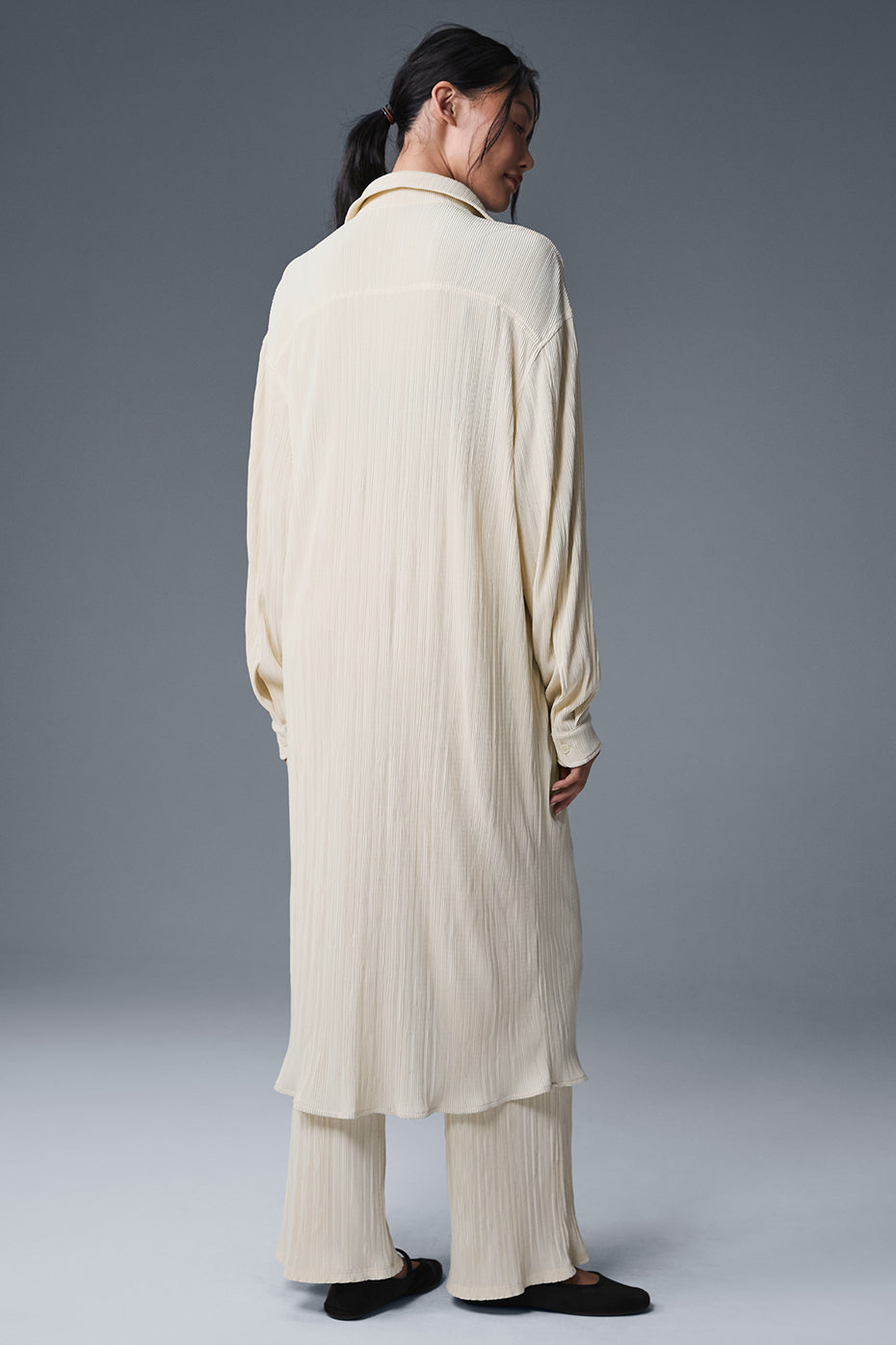 Close-up of the lightweight fabric of the Micro Plisse Shirt Dress in oat milk.