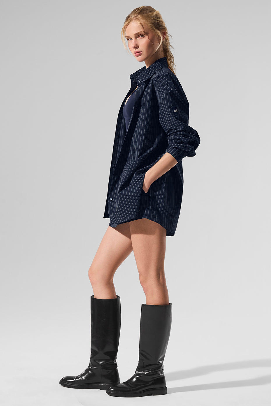 Model wearing navy oversized button down shirt with casual shorts.