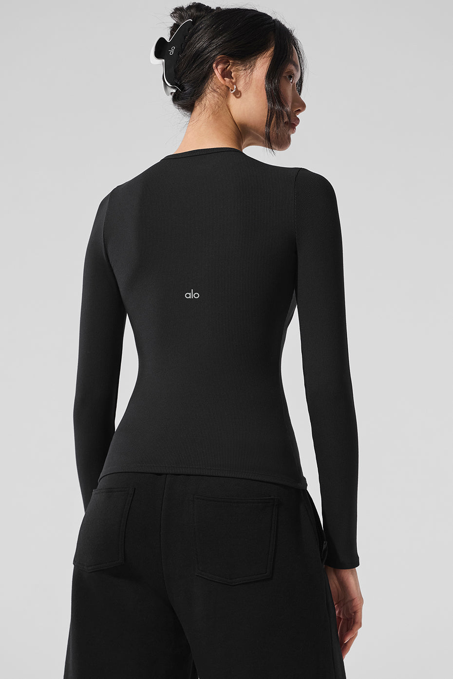 Model styling the Ribbed Modal Long Sleeve Top with casual trousers.