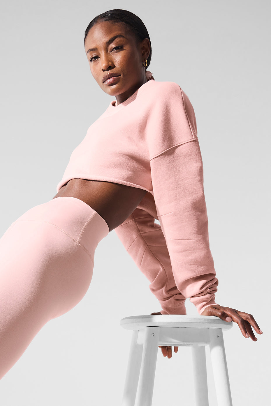 Side angle of the womens black sweatshirt paired with jeans.
