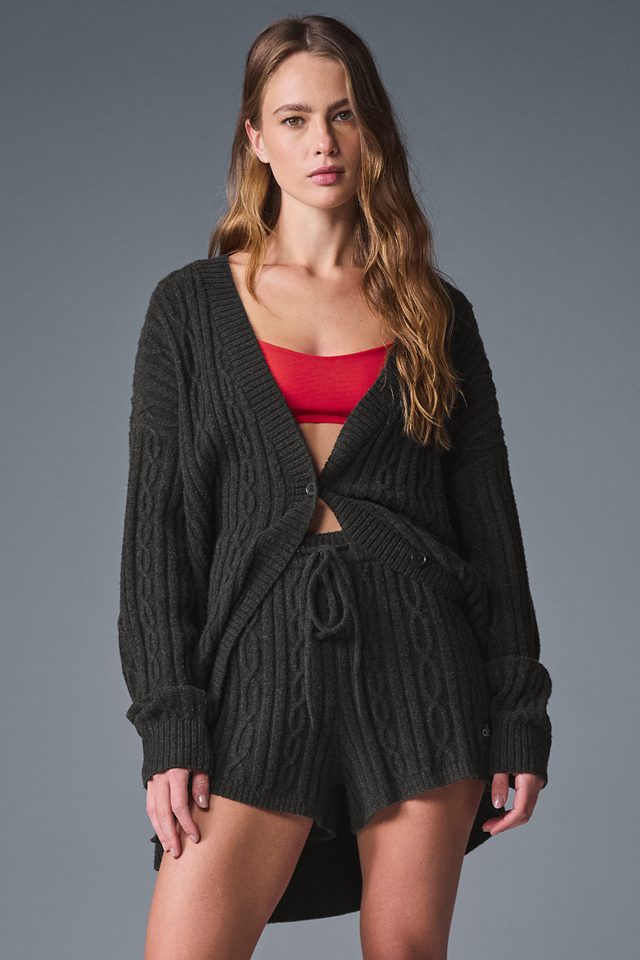 Model wearing oversized cable knit cardigan in dark heather grey.