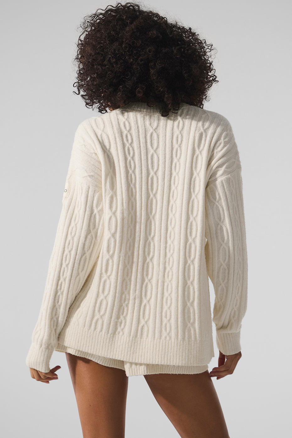 Front view of woman in oversized ivory cardigan outdoor.