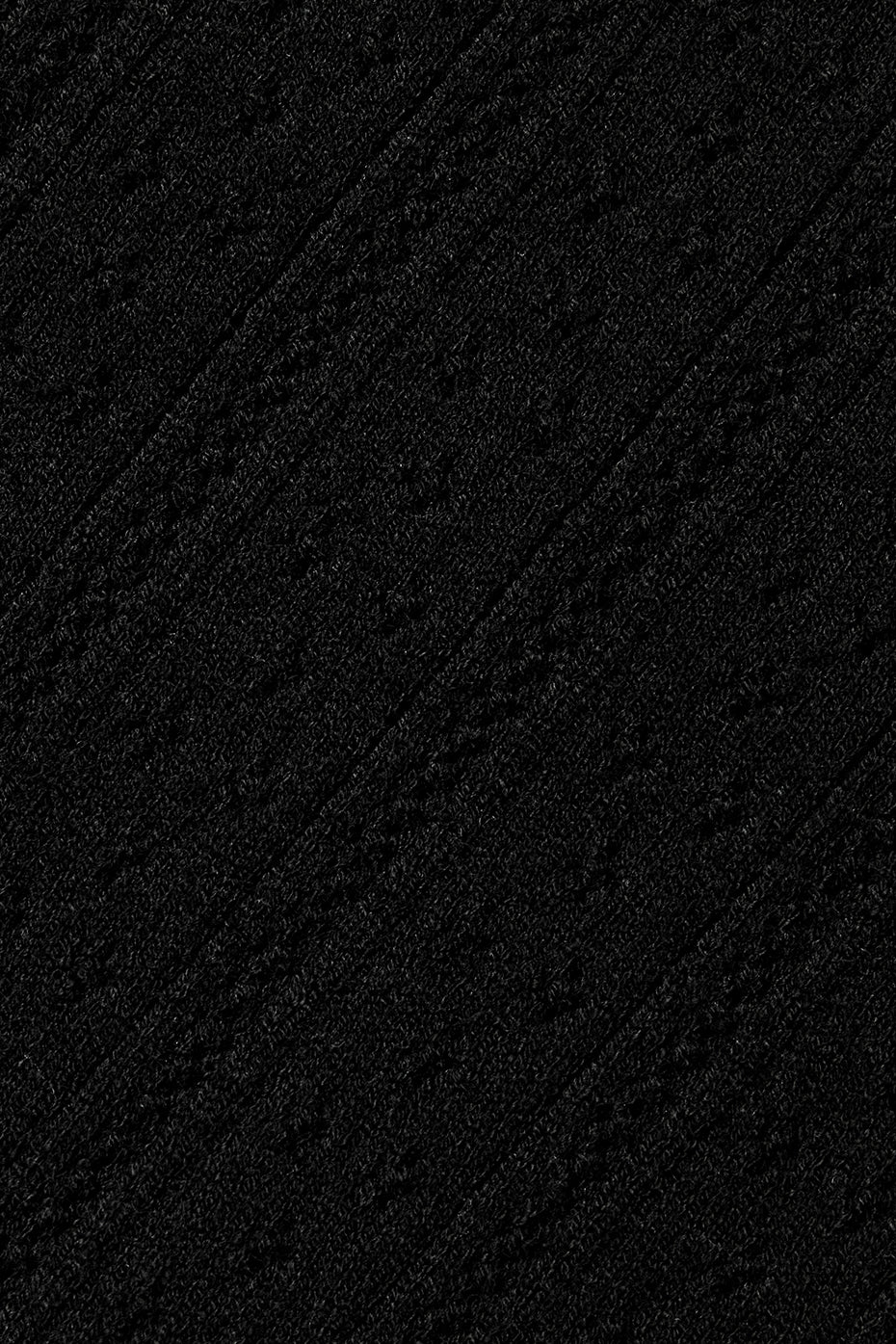Close-up of sheer cardigan sweater fabric highlighting pointelle knit pattern
