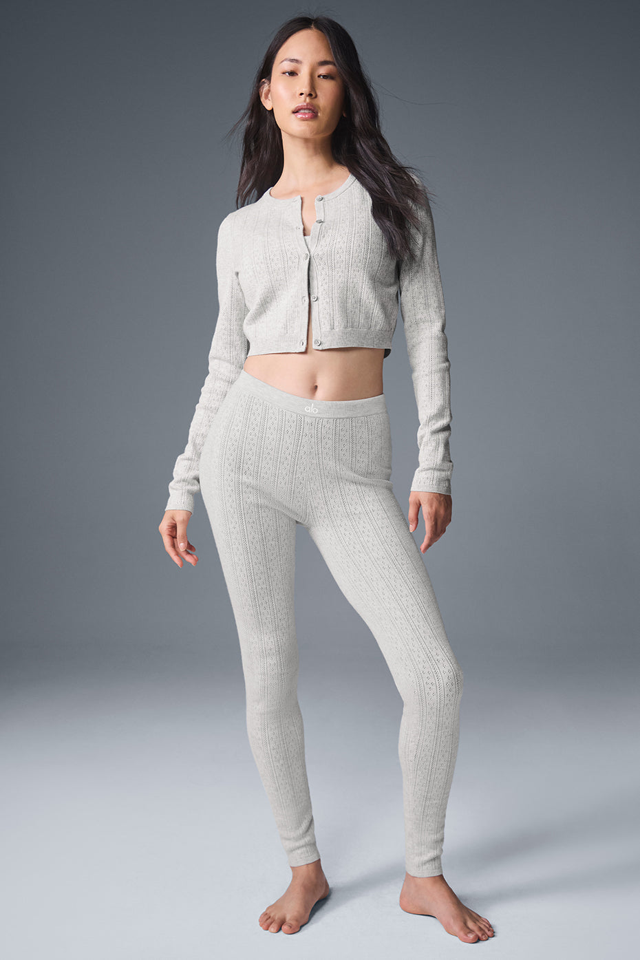 Front view of light grey cardigan sweater styled with leggings.