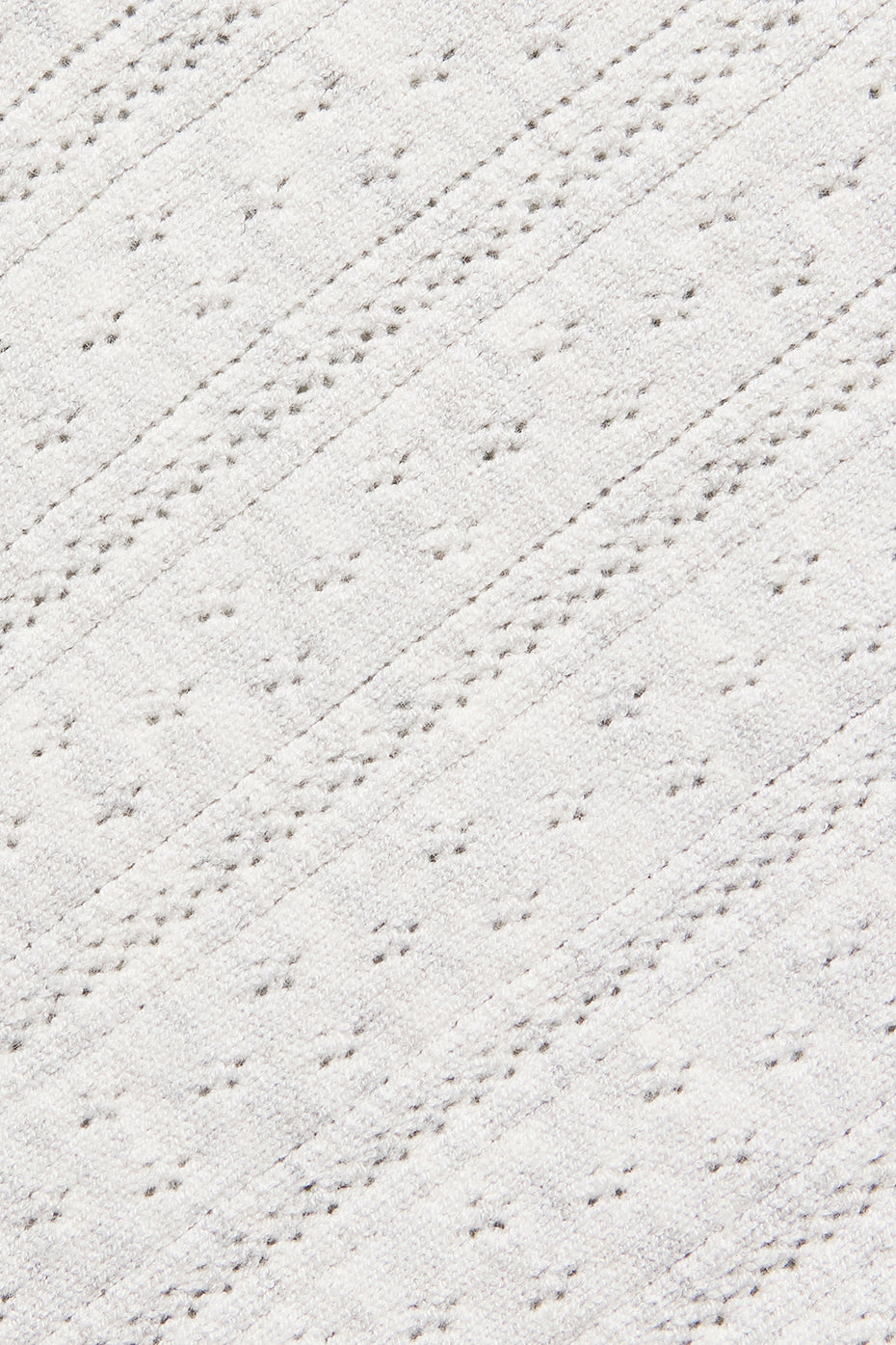 Side view of pointelle cardigan showcasing intricate details.