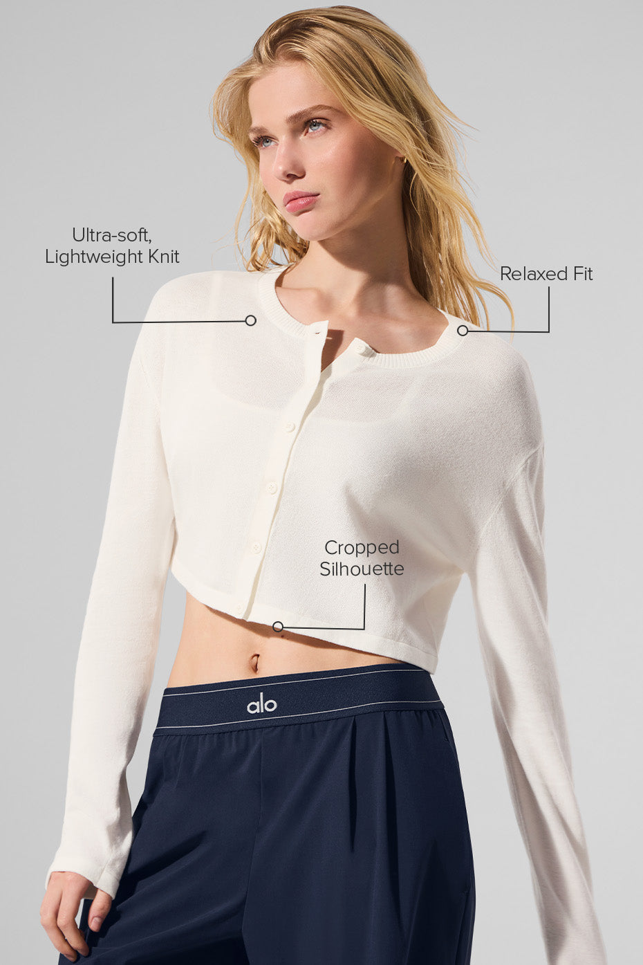 Model wearing the ivory cardigan sweater layered over a casual outfit.