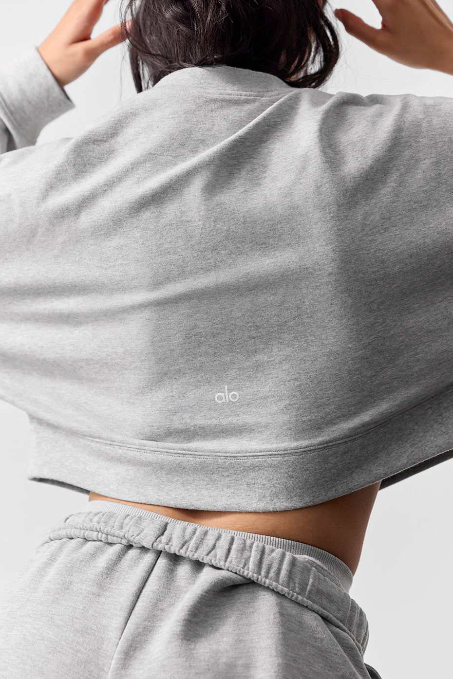 Model wearing cropped pullover with high-waisted leggings for athleisure look