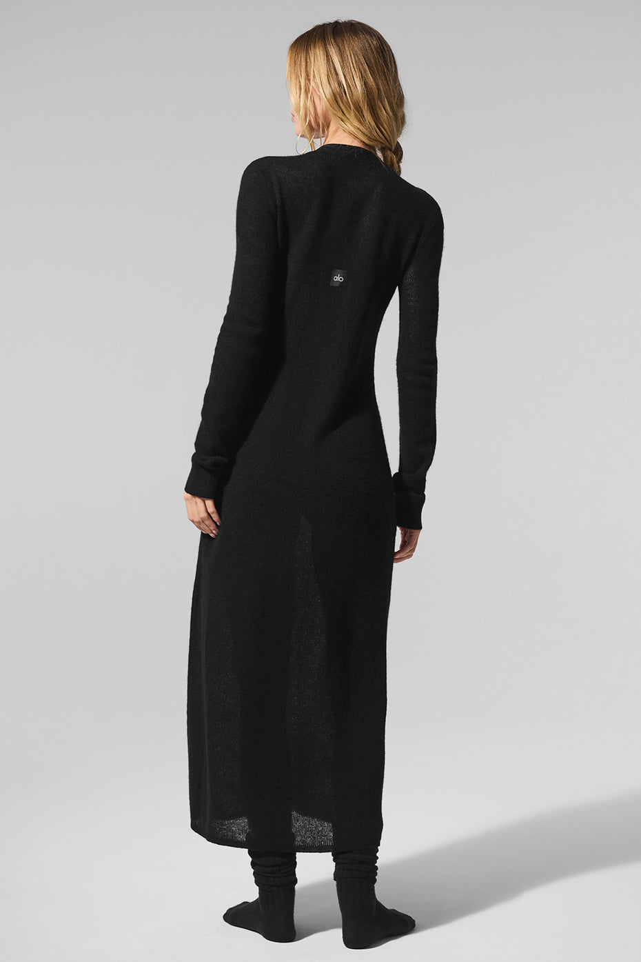 Long cardigan layered with travel gear on a minimalist hanger