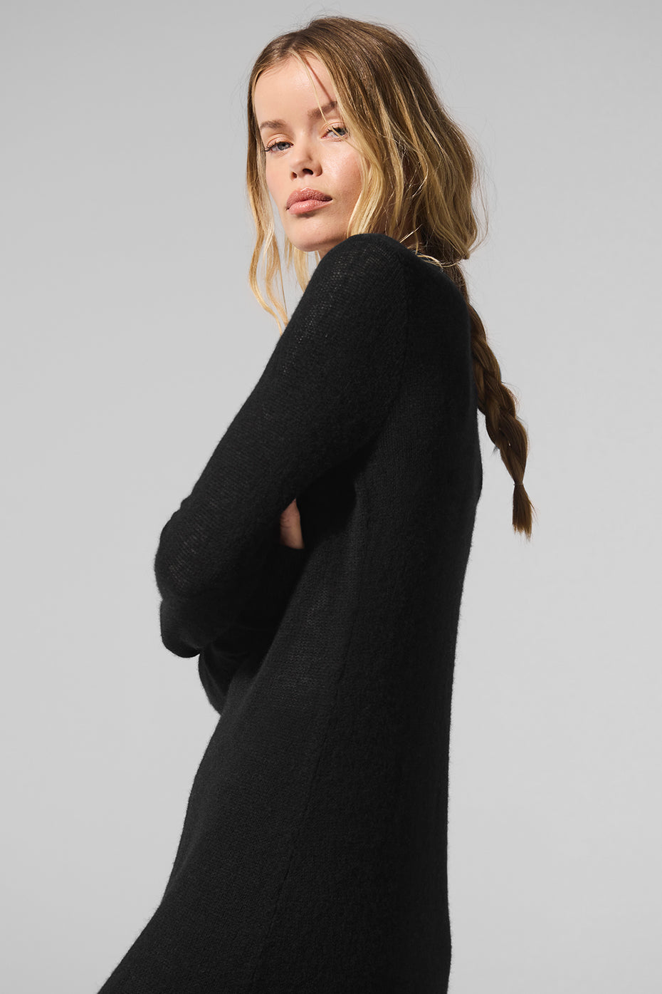 Black cashmere cardigan draped over beachwear at sunset